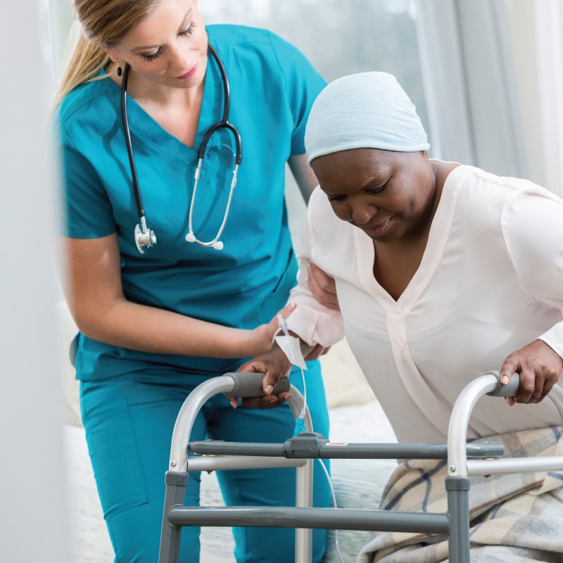 Physical Therapist helping a patient use a walker.