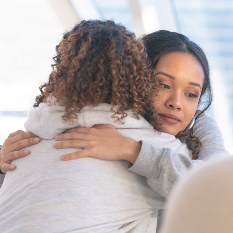 Young patient receiving a hug in group therapy